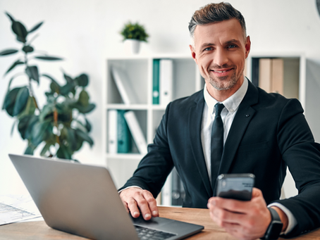 man smiling while holding phone