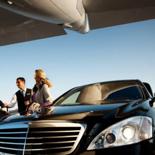 People shaking hands while standing near car