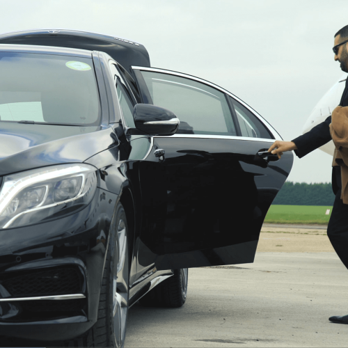 man holding back door of car